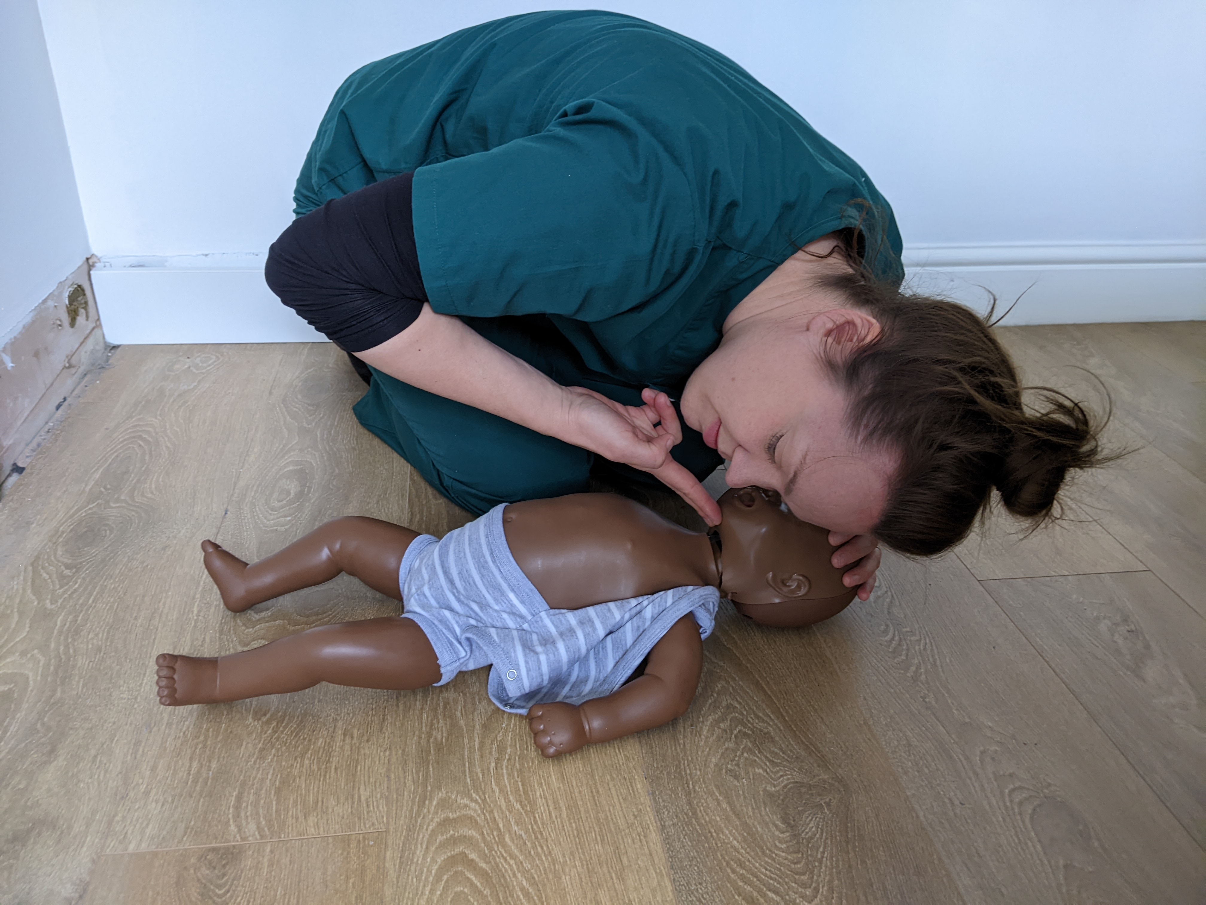 Dr Shiri Lejay demonstrating how to check the breathing of an infant on a training dummy